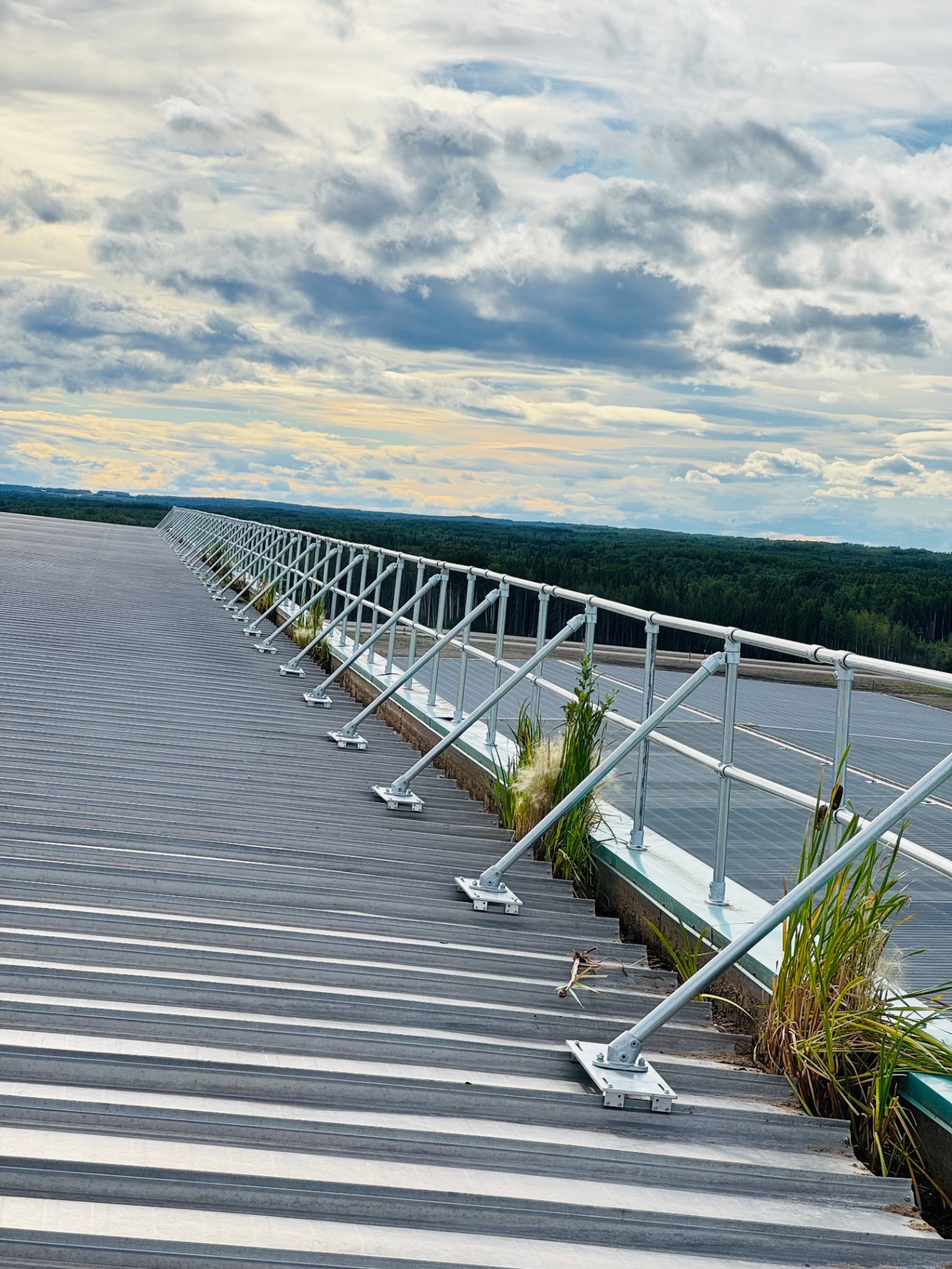 Permanent guardrail safety system installed along the edge of a commercial roof