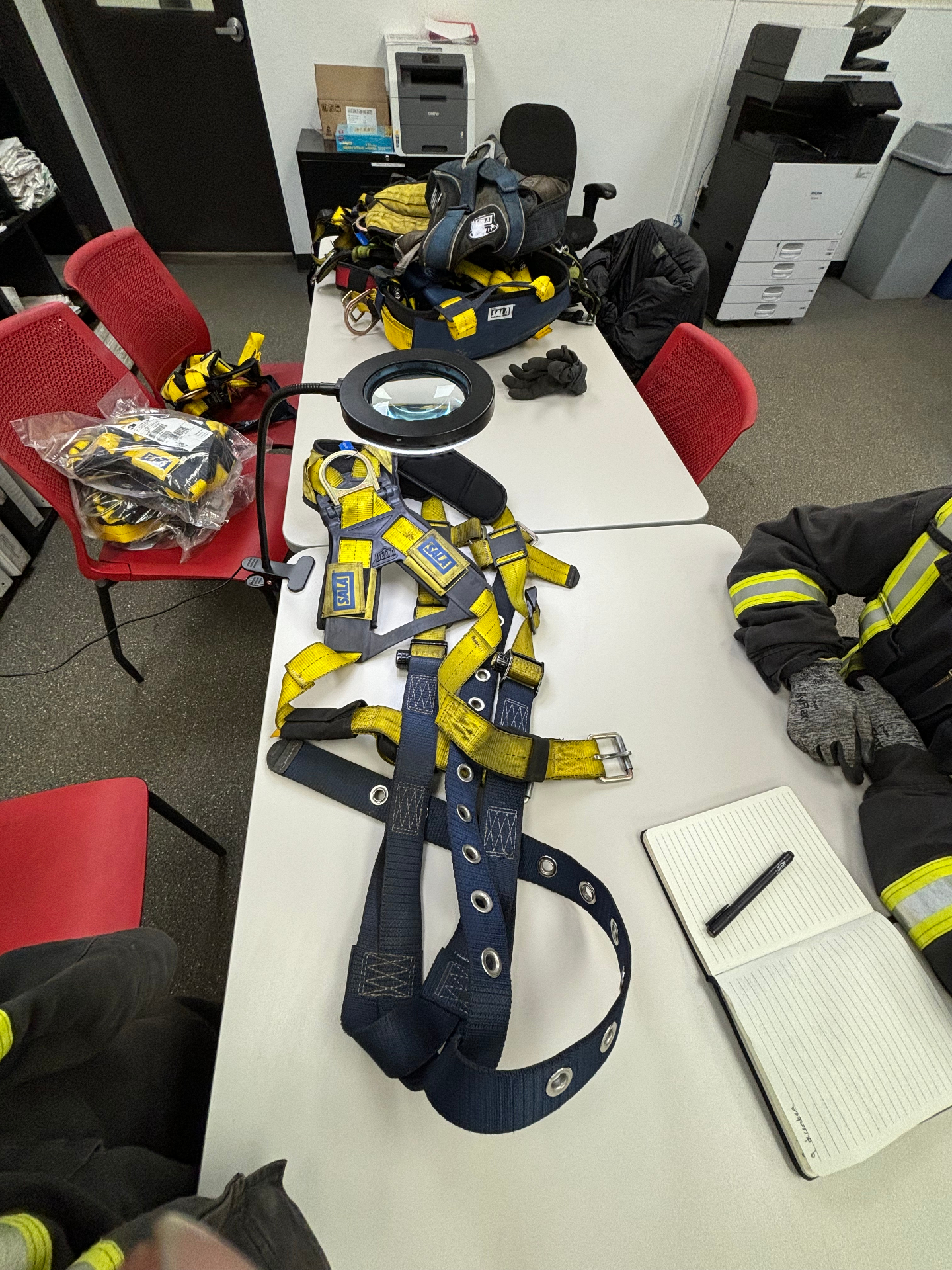 Fall-protection harnesses laid out on a table during a recertification inspection