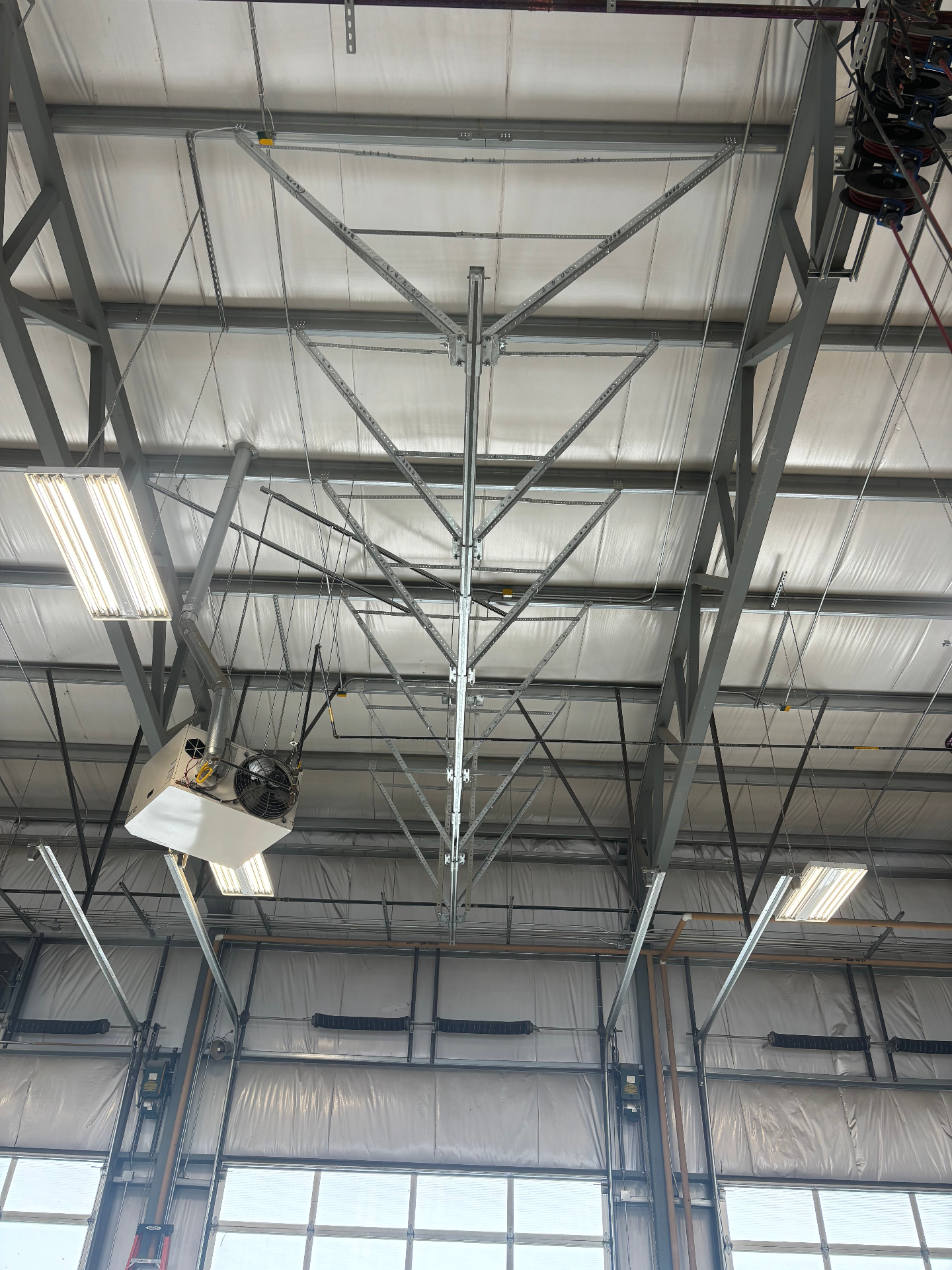 Overhead fall protection track system installed inside an industrial facility